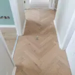 Invisible Light Oak Herringbone Engineered Wood Flooring with a subtle matte finish, showcasing light oak tones and a precisely arranged herringbone pattern