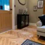 Elegant natural oak herringbone engineered wood flooring, featuring precise V-shaped patterns, rich wood textures, and a durable multi-layered construction