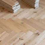 Elegant natural oak herringbone engineered wood flooring, featuring precise V-shaped patterns, rich wood textures, and a durable multi-layered construction