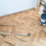 Elegant natural oak herringbone engineered wood flooring, featuring precise V-shaped patterns, rich wood textures, and a durable multi-layered construction