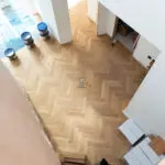 Elegant natural oak herringbone engineered wood flooring, featuring precise V-shaped patterns, rich wood textures, and a durable multi-layered construction