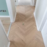 Invisible Light Oak Herringbone Engineered Wood Flooring with a subtle matte finish, showcasing light oak tones and a precisely arranged herringbone pattern