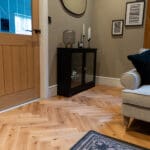 Elegant natural oak herringbone engineered wood flooring, featuring precise V-shaped patterns, rich wood textures, and a durable multi-layered construction