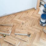 Elegant natural oak herringbone engineered wood flooring, featuring precise V-shaped patterns, rich wood textures, and a durable multi-layered construction