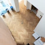 Elegant natural oak herringbone engineered wood flooring, featuring precise V-shaped patterns, rich wood textures, and a durable multi-layered construction