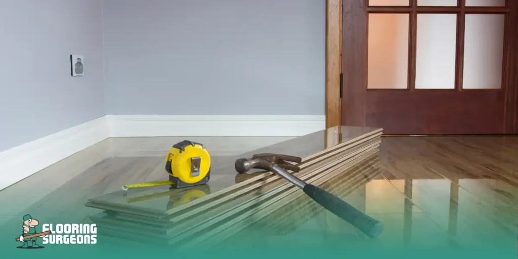 What Color Floor Shows the Least Dirt Stack of dark wood flooring planks with tape measure and hammer, ready for installation near a gray wall.