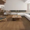 Modern living room interior with Nevada 14/3 x 125mm chestnut lacquered oak engineered wood flooring, showcasing smooth matte finish, warm brown tones, and contemporary furniture setup